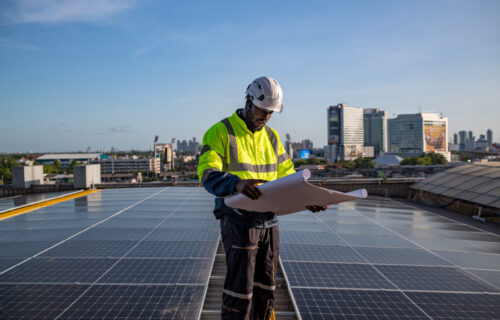 worker-inspecting-solar-panels-blueprint-on-roof-2026-09-24-08-09-58-utc worker-inspecting-solar-panels-blueprint-on-roof-2026-09-24-08-09-58-utc